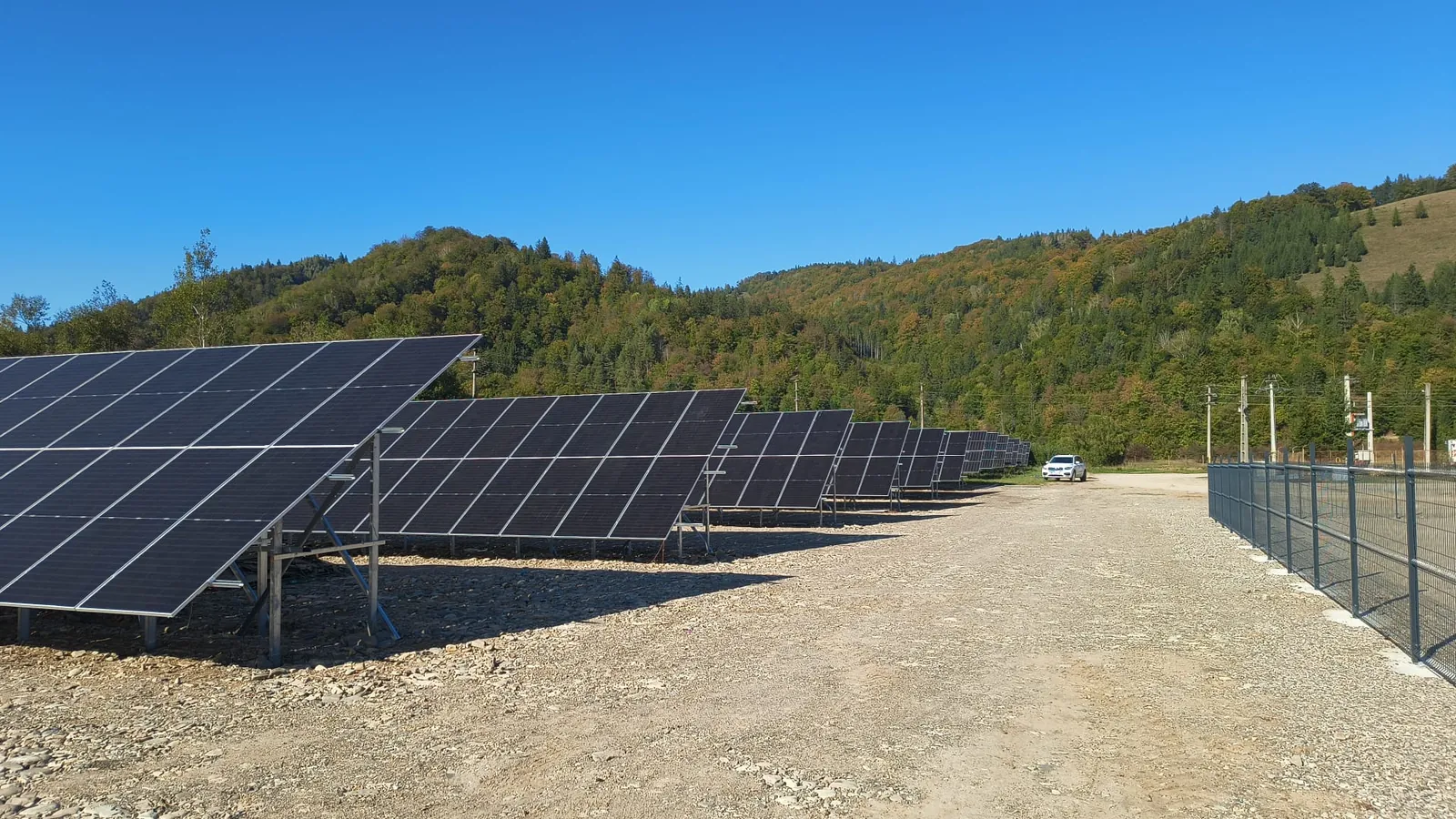 Parc fotovoltaic la sol, cu rânduri de panouri pe structuri metalice